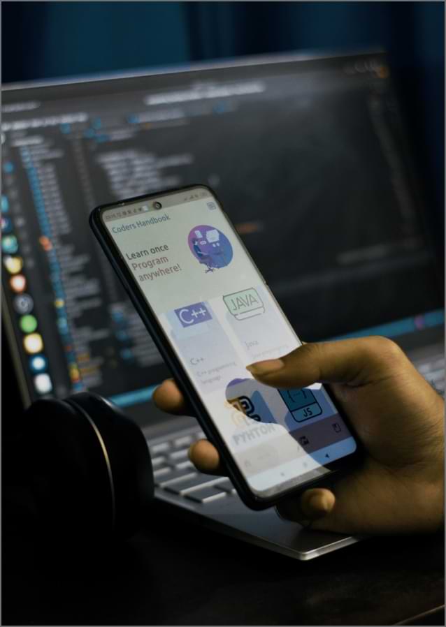 Ein Entwickler-Team bei der Besprechung einer Cross-Plattform-App, die auf einem Bildschirm dargestellt wird.
