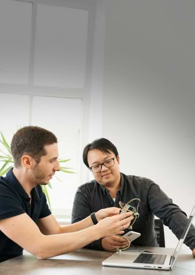 Ein Entwickler arbeitet an einer iOS-App auf einem MacBook, im Hintergrund ist das Apple-Logo zu sehen.